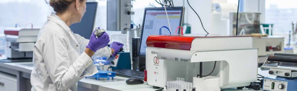 Un tecnico di laboratorio in camice che lavora su una macchina.